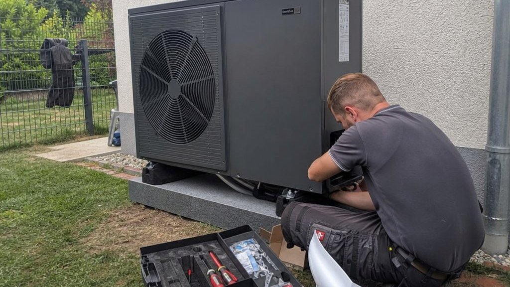 Heizungsbauer bei der Installation einer Wärmepumpe am Einfamilienhaus